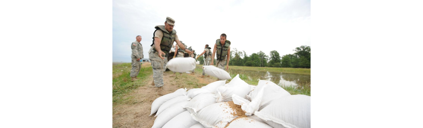 Color image of workers laying sandbags as a flood prevention measure