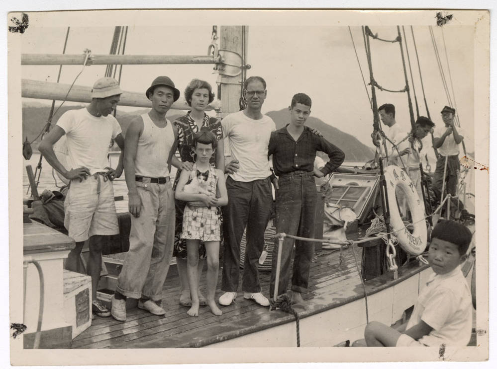 Black and white photograph of a group of people standing on a boat
