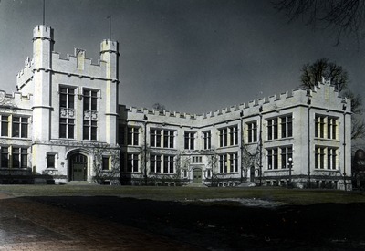 black and white photograph of a large academic building at night